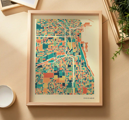 Gerahmtes Chicago Poster von oben auf sandfarbener Fläche, daneben eine Grünpflanze