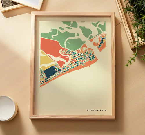 Gerahmtes Atlantic City Poster von oben auf sandfarbener Fläche, daneben eine Grünpflanze